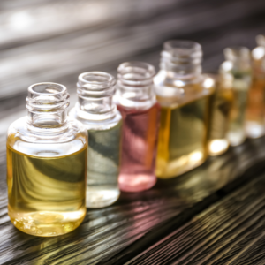 A row of small glass bottles filled with various colored liquids, representing men's fragrances.